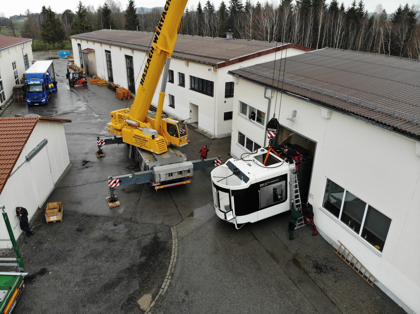 Kran hebt eine DMC 125 FD duoBLOCK bei einem Maschinenumzug